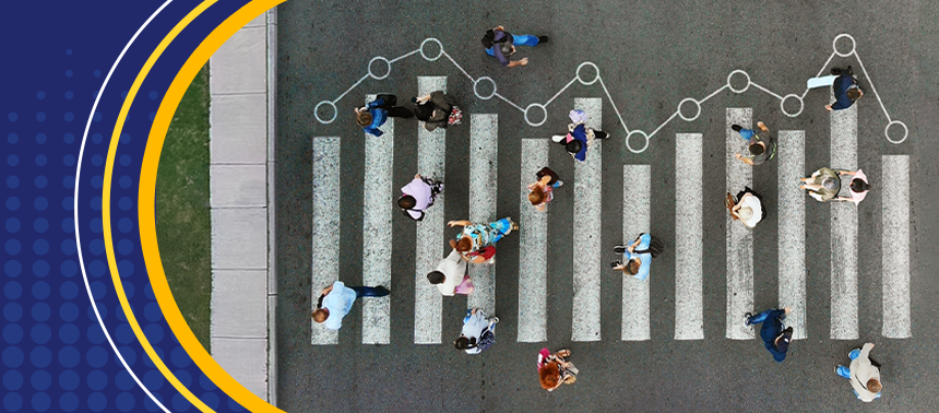 An overhead view of a small crowd crossing a street at a crosswalk, representing ALICE. Data markers connecting the crosswalk lines symbolize the latest State of ALICE research.